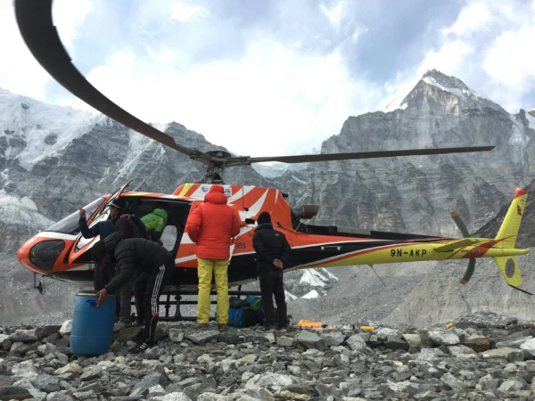 A helicopter and climbers at a high-altitude Himalayas location, Nepal