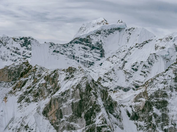 Majestic snow-covered Himalayan mountains under a cloudy sky in Khumjung, Nepal